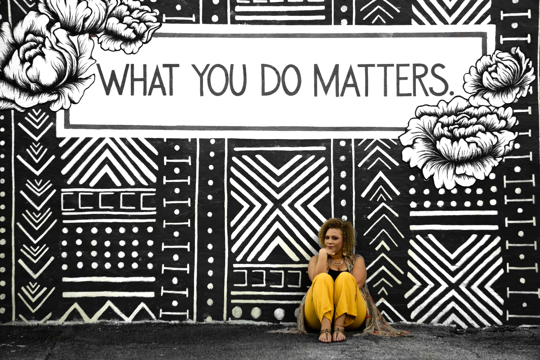 photograph of a woman standing in front of a sign that says, "what you do matters."