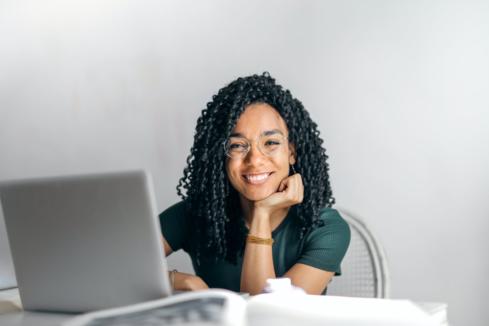 photo of a woman sitting in front of a laptop, smiling