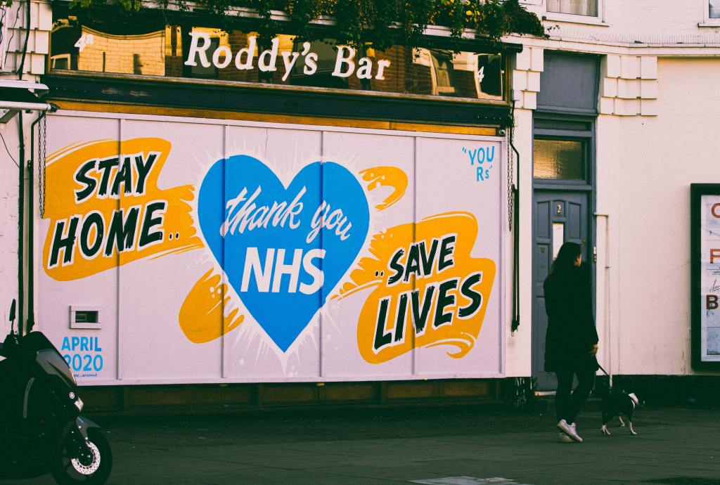 photo of a shuttered bar with the words "stay home, save lives, thank you NHS" painted on it