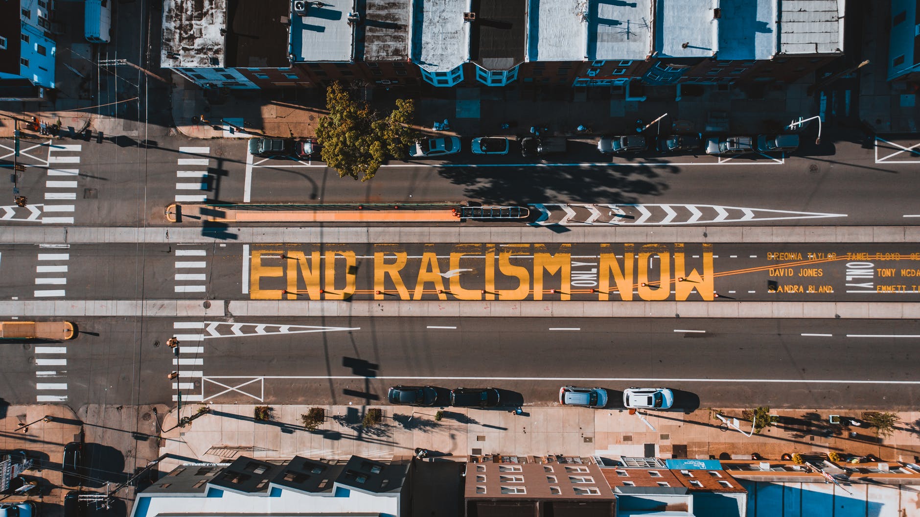birds'-eye-view photo of a street with the words "end racism now" painted, in large letters, on it