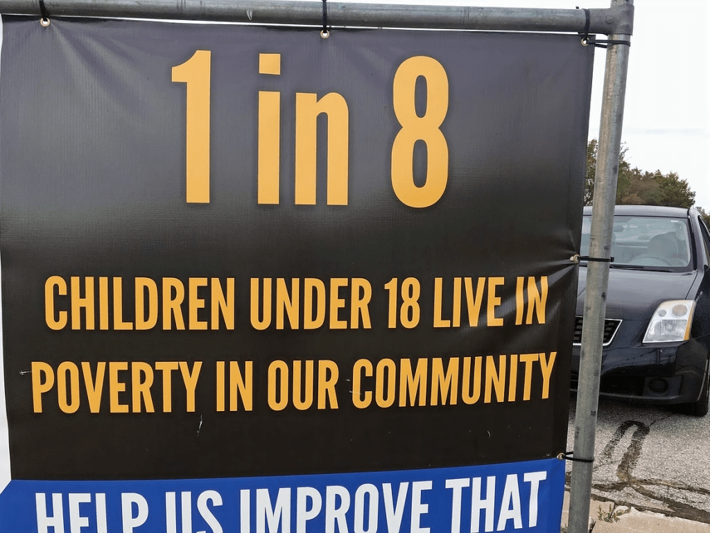 a sign posted in a local community telling citizens about the child poverty rate