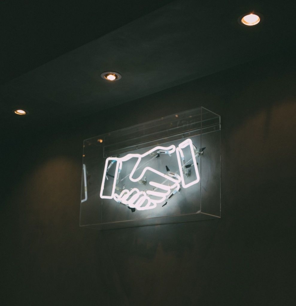 neon sign depicting a handshake