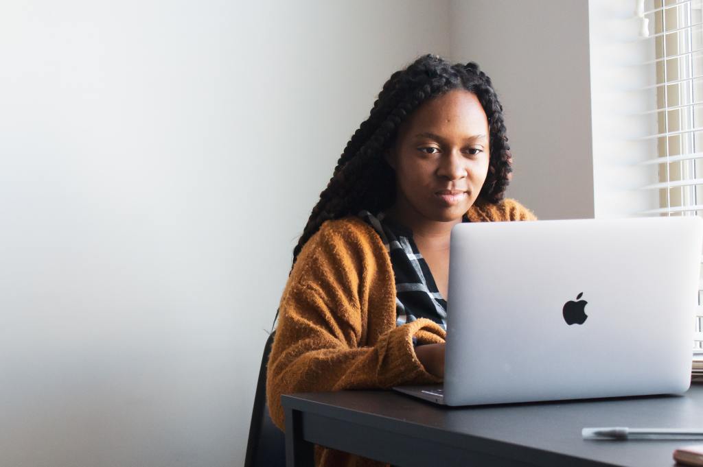 photo of a woman sitting at a laptop, working
