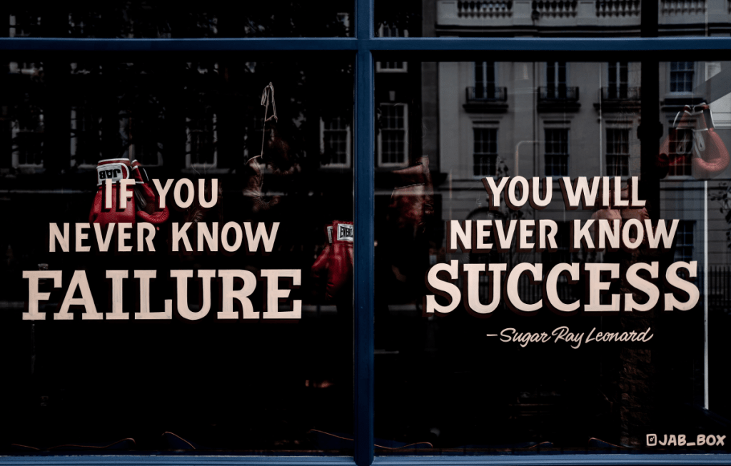 photo of a quote by sugar ray leonard painted on a window that reads "if you never know failure, you will never know success"