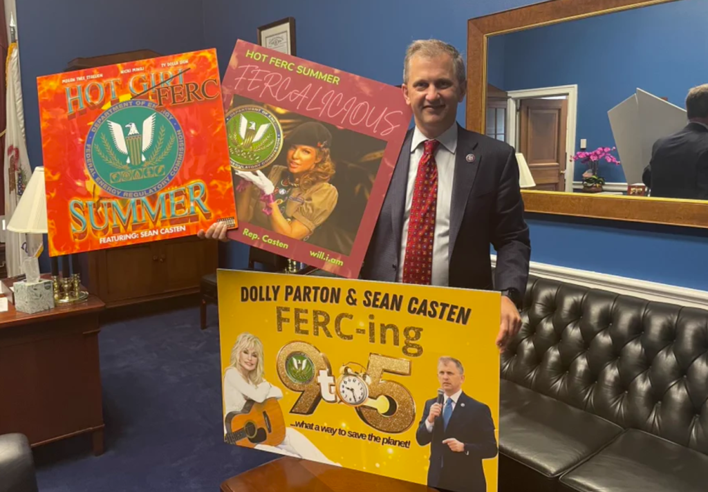 photo of rep. sean casten (d-il-6) holding three signs his office made for #hotFERCsummer