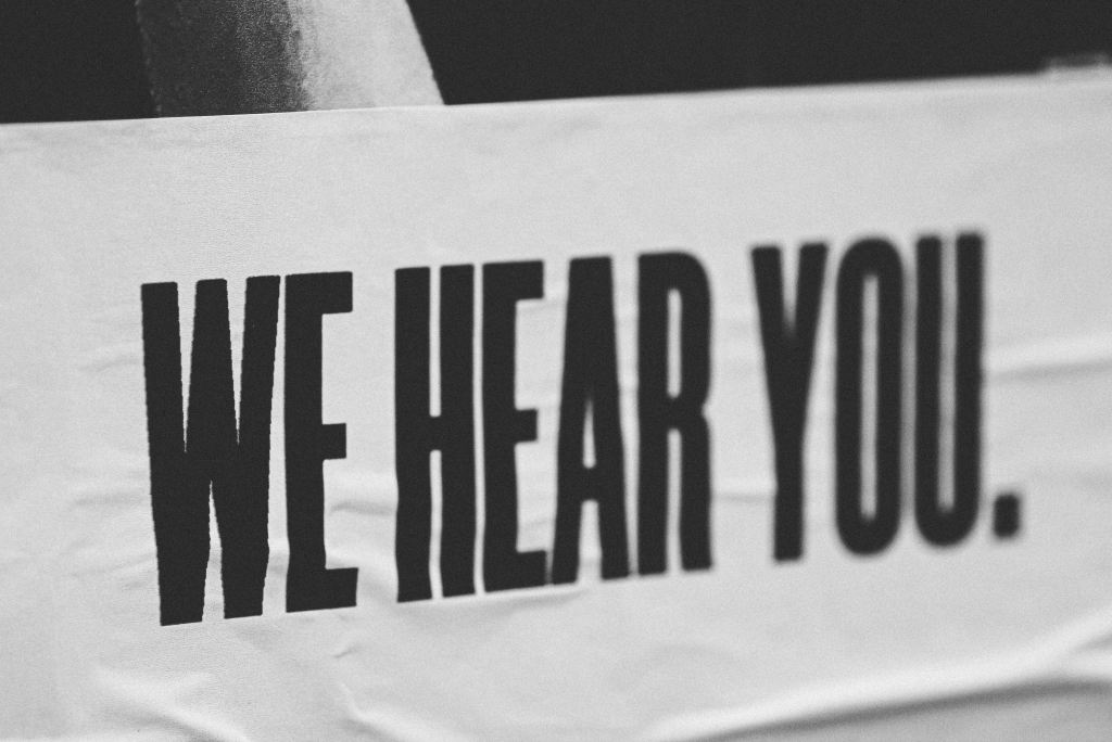 photo of a poster that reads, "we hear you"