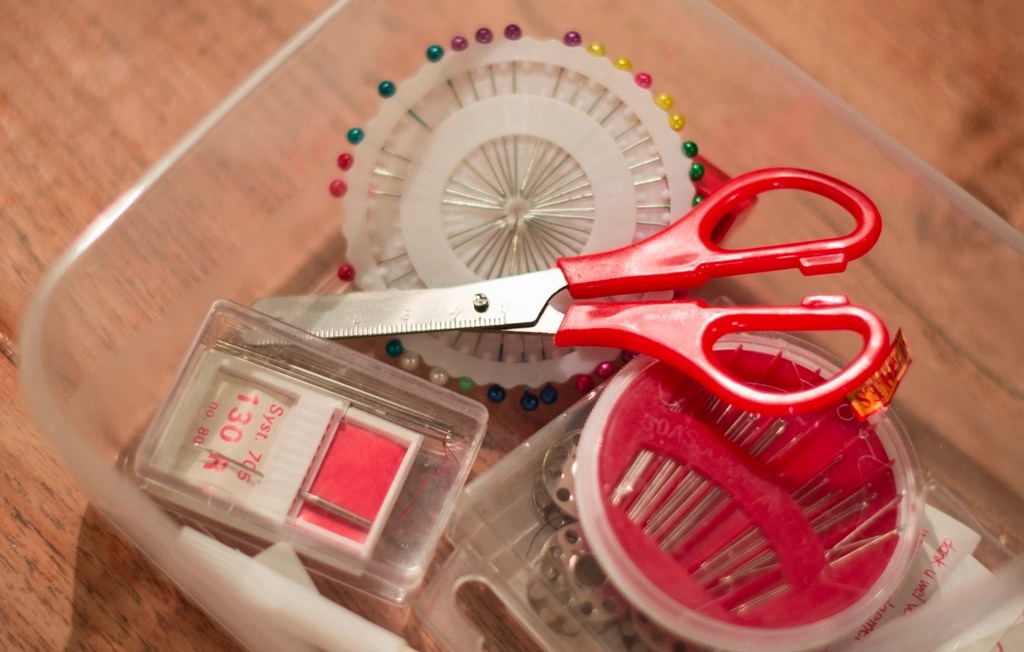 photo of a sewing kit with scissors prominent in the forefront