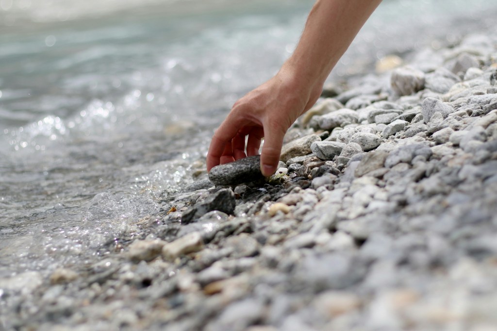 photo of a person picking up a rock